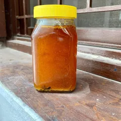 A jar of our golden, rendered pork lard. We infuse it with rosemary and garlic, creating a flavorful fat that is perfect for frying eggs, sautéing vegetables, or adding a rich base to your sauces.