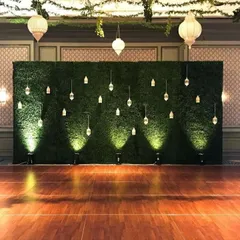 A full shot of the stunning green wall backdrop on a polished wooden floor. This setup is perfect for creating a memorable stage or photo zone at any high-end event.