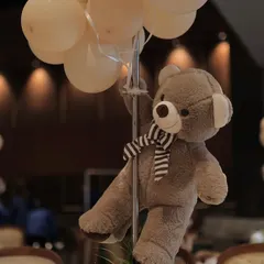 It's all in the details. This adorable teddy bear centerpiece, holding a bunch of balloons, adds a whimsical touch to the guest tables and ties the whole theme together.