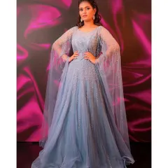 A gown fit for a queen. This powder blue ball gown features elegant cape sleeves and intricate beading, ensuring you look and feel absolutely regal on your special day.