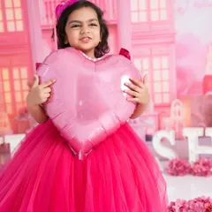 A real-life Barbie doll in a world of pink. This older girl is holding a heart balloon in a beautiful, custom-made Barbie dreamhouse set.