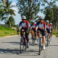 All smiles on two wheels. A front view of our Spokies enjoying a sunny group ride, showcasing the joy and energy of our cycling community.