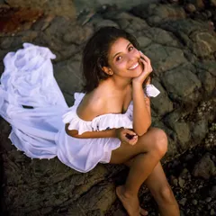 A joyful, high-angle shot that feels spontaneous and happy. The flowing white dress and natural smile make this a perfect lifestyle image.