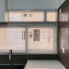 Stylish and practical Venetian blinds installed in a modern kitchen, offering privacy and easy light adjustment over the sink area.
