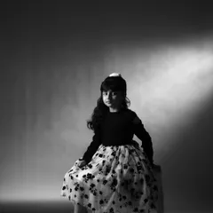 A classic black and white portrait using a single spotlight. This technique creates a timeless, cinematic look that emphasizes her poise and elegance, even at a young age.