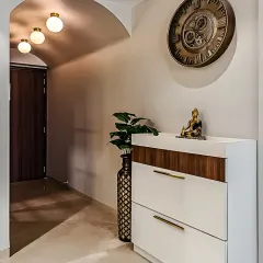 We designed this compact entryway with a modern two-tone shoe cabinet in white and wood. The simple, clean-lined unit provides ample shoe storage while serving as a beautiful console for decorative items.