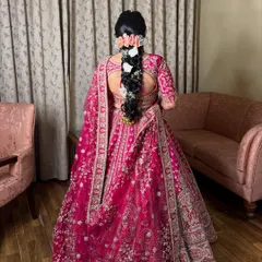 A back view of the complete bridal look, showing a stunning braid adorned with fresh white flowers.