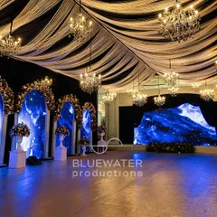 Inside the 'Blue Palace', where arched LED screens displaying a celestial night sky were flanked by classic columns and lush floral arrangements, creating a blend of modern tech and timeless romance.