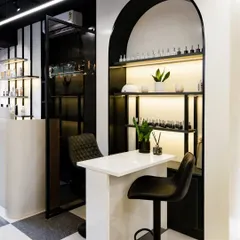 This angle shows how the arched manicure station is integrated into the salon's overall design. The black and white theme continues, creating a cohesive and high-end feel throughout the space.
