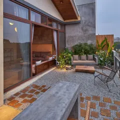 A close-up of the material palette on a residential terrace. The combination of smooth concrete, warm wood blocks, and textured gravel creates a rich sensory experience underfoot, turning a simple balcony into a designed landscape.