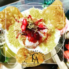 We present classic Bhalla Papdi as a work of art. Served in a crystal glass, each layer is carefully constructed with creamy yogurt, tangy chutneys, crisp papdi, and a garnish of fresh pomegranate, transforming a beloved street food into a gourmet delight.