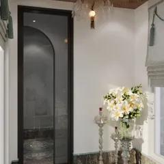The entrance to the mandir is marked by a simple glass door, allowing it to feel connected to the home while still being a distinct, sacred space. A beautiful glass chandelier adds a touch of opulence.