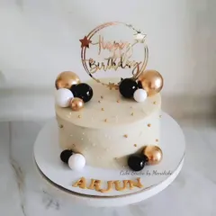 A classy and elegant birthday cake in a timeless black, white, and gold color scheme. This design is completely without fondant, decorated with spheres and a custom topper.