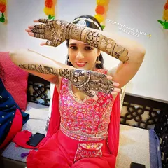 A beautiful bride-to-be posing with her intricate back-hand mehandi during her henna ceremony.