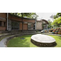 The campus is designed as a series of interconnected spaces. The view from the main building looks out onto the central amphitheater, reinforcing the link between indoor learning and outdoor community activities.