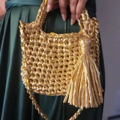 A close-up view of the 'Golden Girl' crochet bag, showing the texture of the crochet stitches and the shiny tassel. I pay close attention to every detail to make sure each bag is special.