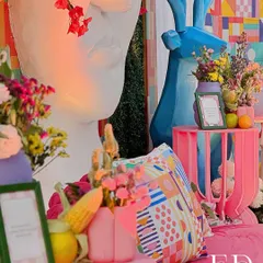 An explosion of color at a carnival-themed event, with quirky elements like a blue deer sculpture, geometric-print cushions, and fresh corn used as decor. This design is all about playful energy and sensory delight.