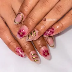 Serving serious nail goals with this elegant set. It features a translucent base with delicate pink floral art, gold swirls, and gold-lined cuticles.