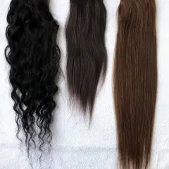 I offer a wide range of textures and colors to ensure a perfect match for every client. This image displays some of my most popular options, including natural black curly, dark brown wavy, and straight light brown extensions.