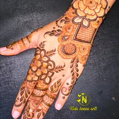 An elegant floral design perfect for Eid celebrations. This style combines bold flowers with delicate leaves and net patterns, creating a beautiful look for the back of the hand.