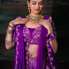 A close-up shot focusing on the bride's jewelry and the detailed embroidery on the blouse. This type of shot is essential for showcasing the craftsmanship of bridal couture.