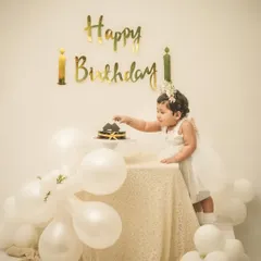 An elegant first birthday setup in white and gold. This little princess is curiously reaching for her very first birthday cake, a precious moment to capture.