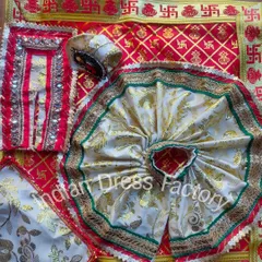 A complete wedding-themed set for Laddu Gopal. This custom vastra includes a red and gold brocade outfit with mirror work, set against a traditional red asana cloth with swastika motifs.