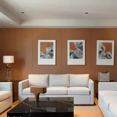 The waiting area at Jubilee Headquarters, featuring a warm, earthy color palette and a black marble coffee table. The space is designed for comfort and understated elegance, with curated art and soft lighting creating a welcoming atmosphere for visitors.