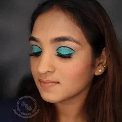 With eyes closed, you can see the precision of the floating crease eyeliner that defines this 1960s look. The solid block of teal eyeshadow is a hallmark of the era's bold and experimental approach to color.