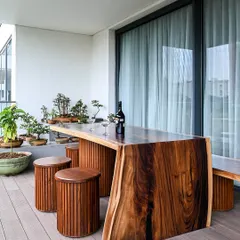 Craftsmanship is at the heart of our work. This monolithic live-edge deck table, paired with custom stools and a collection of bonsai, creates a stunning and unique outdoor space for relaxing and entertaining.