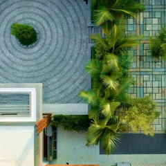 An overhead view of a villa's landscape design, where we balanced softscape with hardscape to adhere to the client's religious practices. The driveway features pavers in a radiating ripple pattern, creating a visually striking contrast with the geometric and natural textures of the garden.
