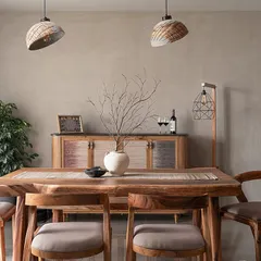 This dining room embodies a Wabi-Sabi aesthetic, celebrating natural imperfection. The walls are finished with a soft limewash, creating a beautiful backdrop for the custom live-edge dining table. The crockery console features unique shutters made from banana fibre, and concrete cane pendants add warmth and texture.