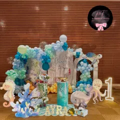 An enchanting 'One-der the Sea' first birthday celebration for baby Ayra. This full view showcases the cohesive underwater theme with blue balloon waves, adorable sea creature cutouts, and personalized marquee letters.