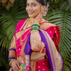 The complete look of a bride in her pink and purple Nauvari. The drape is complemented by a kamarband (waist belt) and intricate henna, showcasing the full splendor of a Marathi Navari.