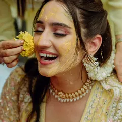 A close-up of the bride's joyous expression during her sunflower-themed Haldi. I focus on making every ritual feel personal and full of happiness, creating picture-perfect memories.