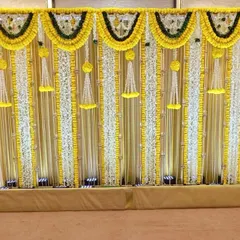 For this Mandap Mahurat puja, we used a vibrant yellow marigold theme. The stage backdrop features strings of genda phool and white flowers, creating a traditional and auspicious setting for the ceremony.