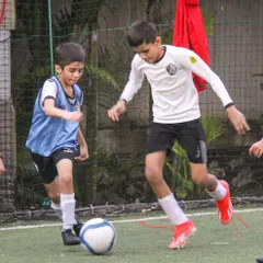 Two players challenge for the ball in a 1-on-1 duel, demonstrating the competitive edge and determination fostered in our training.