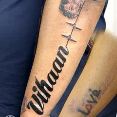 We turned a faded memory into a timeless tribute. This piece was designed to cover an old, colorful tattoo with the name of the client's son, "Vihaan," connected by a heartbeat line to his portrait. It's a beautiful example of how a cover-up can become the most meaningful tattoo of all.