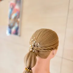 Our faculty demonstrates how to create a chic and modern bubble braid. This style is embellished with small pearls and gold bands, making it a popular choice for festive events.