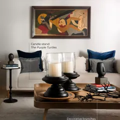 I am never afraid to style with black, because when used with intention, it elevates a room. Here, black candle stands and a side table add depth and definition, grounding the neutral sofa and making the client's artwork shine brighter.