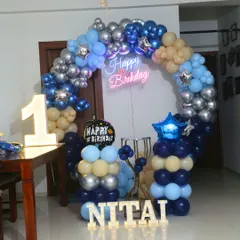 A compact space theme decoration perfect for home parties. It features a circular balloon arch, a neon sign, and a light-up number '1'.