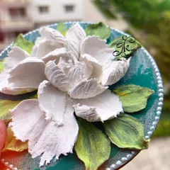 A close-up of a 6-inch fridge magnet featuring a large, elegant white flower on a deep green background.