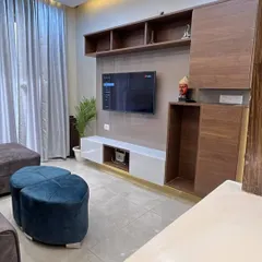 The TV unit in our Gurgaon project combines dark wood with a white console. We also added a small niche for placing decorative items like a Buddha statue.