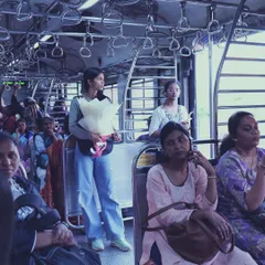 A wider view of the women's compartment in a Mumbai local. It shows the diverse faces and stories of women traveling together, each in their own world.