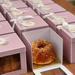 A peek inside our baby announcement favour boxes. Each one holds a delicious mini bundt cake, perfectly packaged in a box with a clear window to showcase the treat inside.