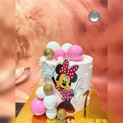 A sprinkle of Minnie Mouse magic for a first birthday. This pretty pink cake features a Minnie cutout, decorated with pink, white, and gold spheres for a touch of sparkle.