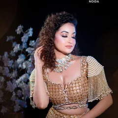 This portrait captures the essence of modern glamour. The combination of curly hair, a bold necklace, and perfectly sculpted makeup demonstrates the high-fashion looks taught in our academy.