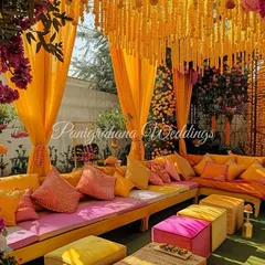 A mesmerizing Mehendi setup, rich in color and detail. We used custom-dyed cushions in shades of orange and pink, with a ceiling of hanging marigolds to create a vibrant and luxurious lounge area.