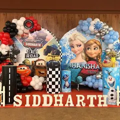 I can create unique combined themes for shared parties, like this "Cars" and "Frozen" setup for twins. Each side has its own distinct characters and color scheme, united by balloon arches and personalized name displays.