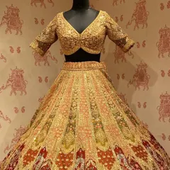 A similar multi-toned bridal lehenga, highlighting the rich combination of gold, red, and green embroidery perfect for a bride.